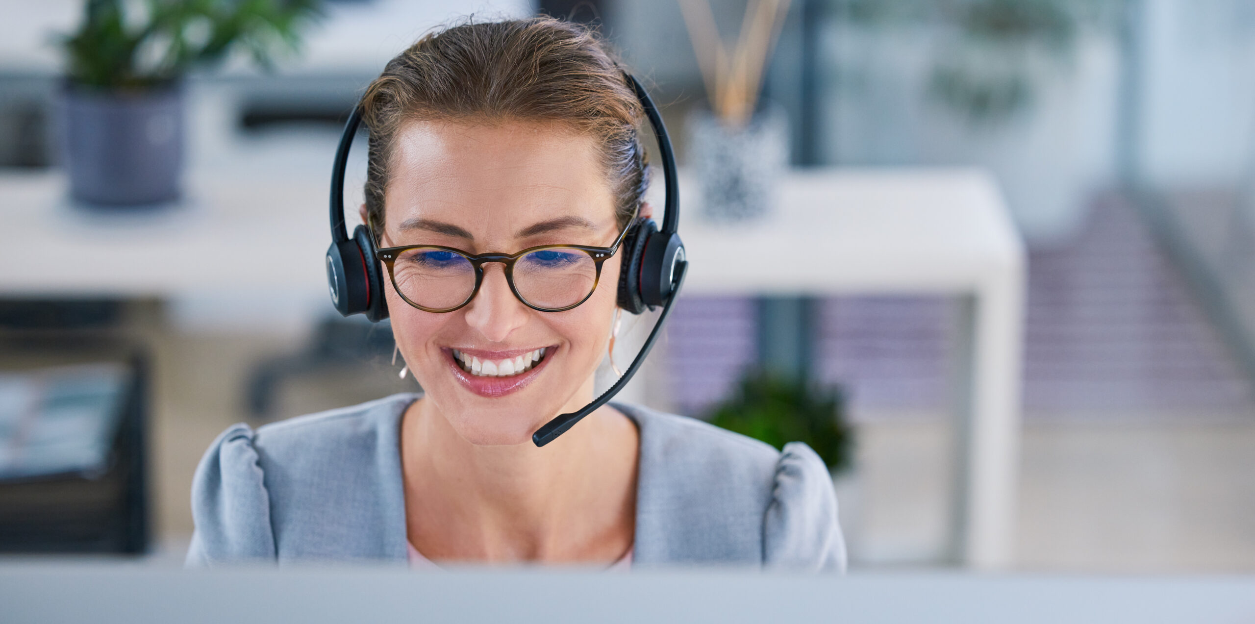 195 / 5.000 Ein freundlicher, lächelnder Callcenter-Mitarbeiter oder Telemarketing-Mitarbeiter mit Headset arbeitet im Büro. Ein Vertriebsberater am Helpdesk für Kunden- und Serviceunterstützung lächelt ebenfalls.